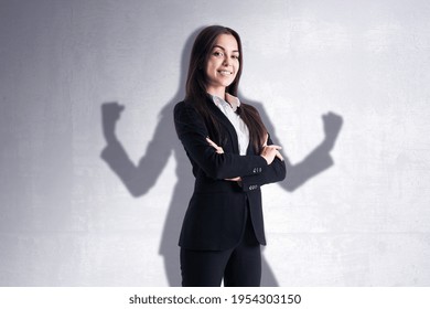Leadership and power concept with confident businesswoman on her shadow background on light wall