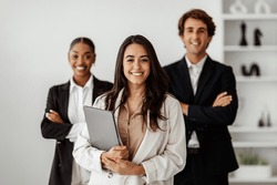 Leadership. Successful Latin Businesswoman Holding Laptop In Hands, Standing With Diverse Business Team In Office. Career Growth Motivation, Entrepreneurship Concept