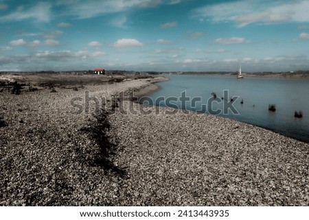 A leading shingle shoreline carries you to a small fishing hut on the horizon captured at Rye Harbour Nature Reserve, Sussex