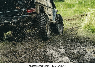 Leading Up Through The Extreme Trails. SUV Or Offroader On Mud Road. Car Racing Offroad. Offroad Car In Action. Dirty Car Drive On High Speed. Car Wheels On Steppe Terrain Splashing With Dirt.