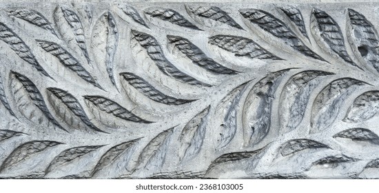 leaf pattern carved on an old stone wall, ancient texture background, vintage relief.