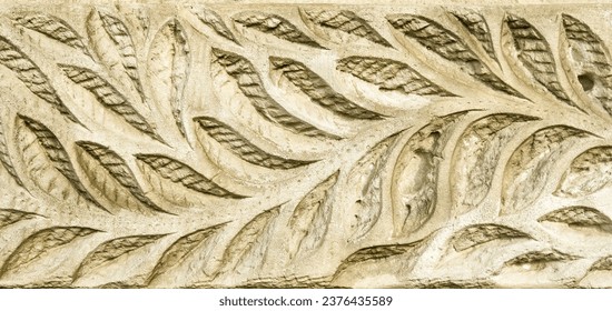 leaf pattern carved on an old stone wall, ancient texture background, vintage relief.