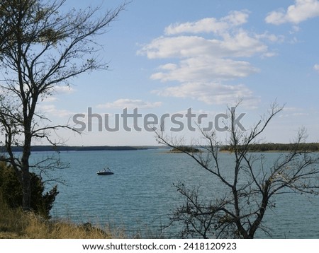 Leafless trees along the bank of Lake Murray Oklahoma on a beautiful day.