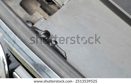A leak of technical fluid in the engine compartment of the car. Car malfunction concept. Leakage, close-up