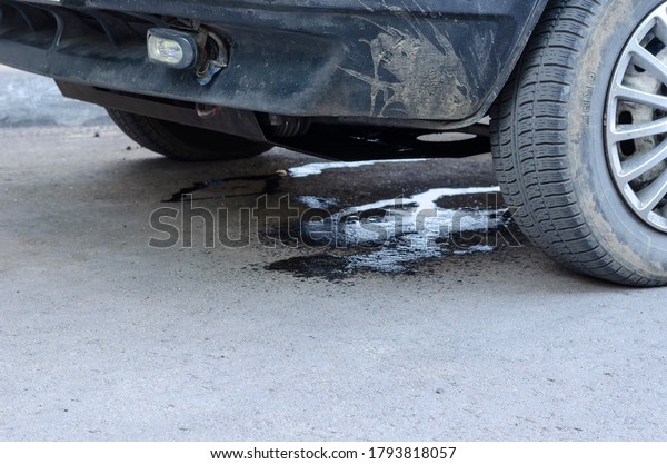 Leakage of antifreeze on the\
asphalt from damaged car. Damage to the cooling system due to road\
traffic accident. Traffic control, insurance. Selective\
focus.