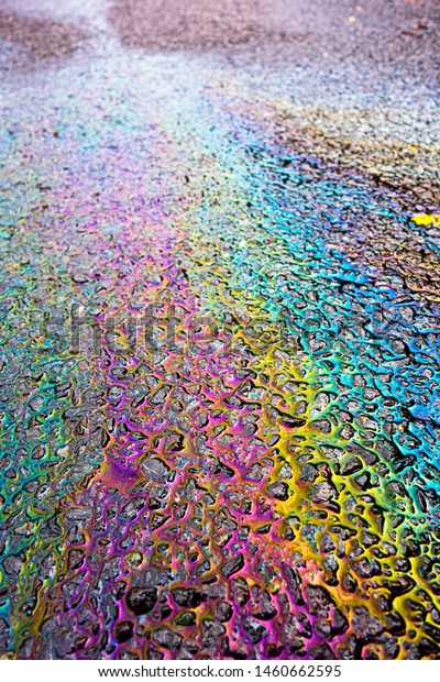 A leaked Car Oil Petrol in The Rain on a Tarmac\
Road Metallic Rainbow