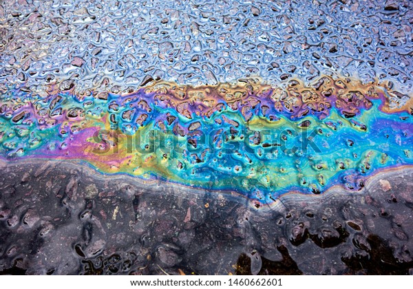 A leaked Car Oil Petrol in The Rain on a Tarmac\
Road Metallic Rainbow