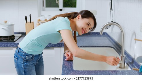 Leaking Faucet In Kitchen - Asian Woman Hand Turn Off  Water Dripping From Tap