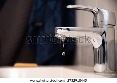 Leaking faucet with single drop falling into sink