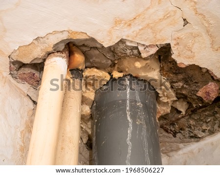 Leaking sewer pipe in the bathroom ceiling. A destroyed ceiling with water stains. Flooded by the neighbors from above.