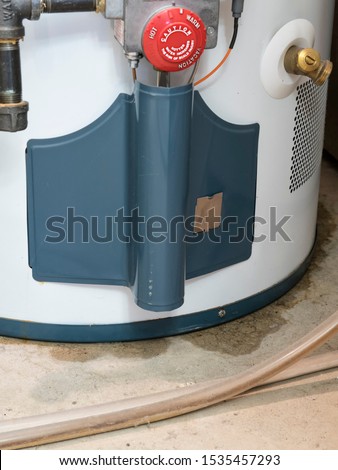 A leaking water heater, showing the regulator dial and pipe marked Water, sits in a utility room, with a puddle of water emerging from the bottom of it