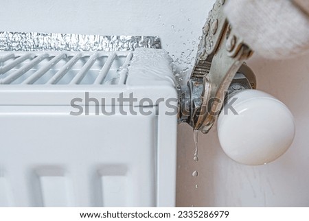 Leaking water from the nut threaded connection of the hot water pipe of heating radiator at home. Plumber at work. 