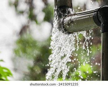 Leaky rain gutter pipe in the midst of a downpour