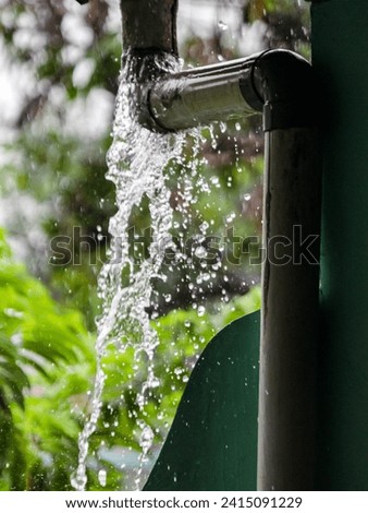 Leaky rain gutter pipe in the midst of a downpour