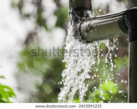 Leaky rain gutter pipe in the midst of a downpour