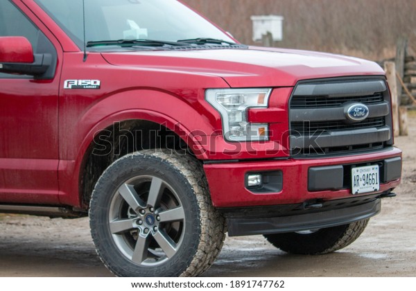 Leamington\
Canada, January 05 2021: Editorial photograph of a ford F150 with\
large winter tires that are all muddy from off road driving. Ford\
f150 is popular truck. High quality\
photo