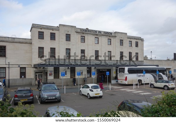 LEAMINGTON\
SPA, ENGLAND - OCTOBER 10, 2019: Parked cars and a coach in front\
of Leamington Spa railway station in\
England