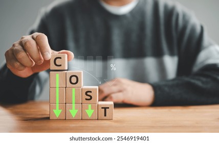 Lean or Cost reduction concept. Optimize manufacturing management. Decreasing company expense to maximize profits. Hand puts a wooden cube with words cost and green down arrows. Business improvement.