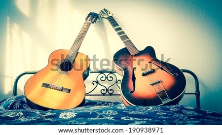 lean on me - two guitars on bed leaning against each other