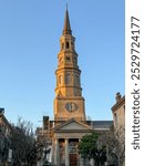 A leaning church steeple at sunset in Charleston SC