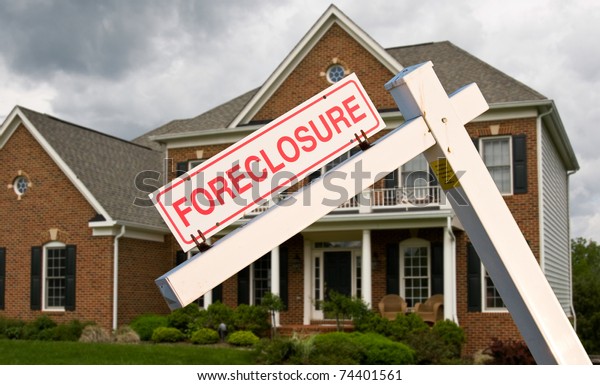 Stock photo of foreclosure sign in front of modern single family house