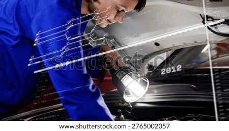 Leaning mechanic in jacket inspecting engine bay at shop, holding lamp near windshield 2012. Technician, automotive, garage, worklight, maintenance, tools, diagnostic