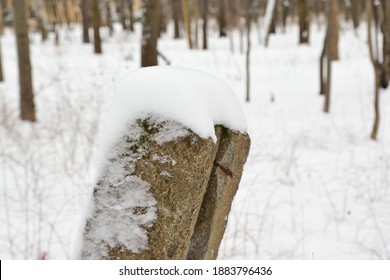 A Leaning Post From A Fence In A Park With A Cap Of Snow On Top