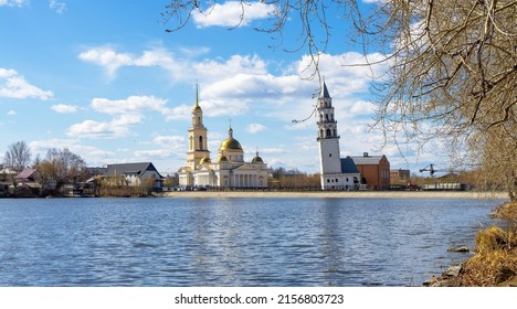 Leaning Tower of Nevyansk and Old Believers' church (domed) in spring day on the shore of the pond in Sverdlovsk Oblast, Russia.