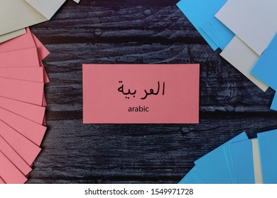 Learn Arabic. Colored cards for learning words on a dark wooden table. Pink
