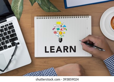 LEARN CONCECT man hand notebook and other office equipment such as computer keyboard, digital tablet, pencil,