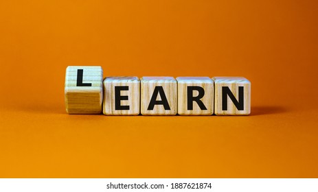 Learn or earn symbol. Turned a cube and changed the word 'earn' to 'learn'. Beautiful orange background. Business and learn or earn concept. Copy space.