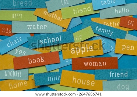 Learn english, Basic Vocabulary for Language Learning, first essential words written on colorful papers - apple, book,  cat, school