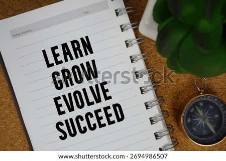 Learn, Grow, Evolve, Succeed text written on notebook paper with compass