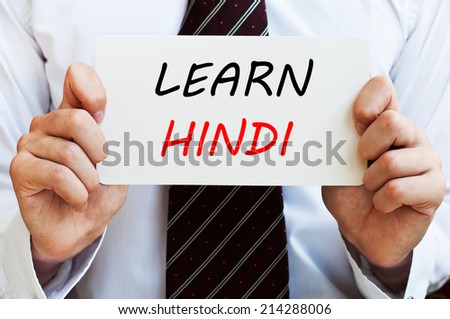 Learn Hindi - man wearing a shirt and a tie holding a signboard with a text on it. Education concept.