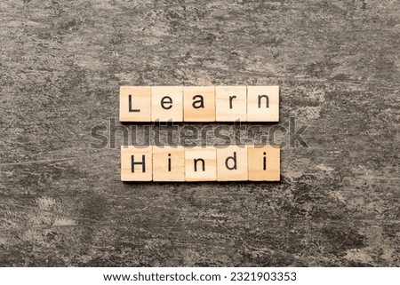 Learn Hindi word written on wood block. Learn Hindi text on table, concept.