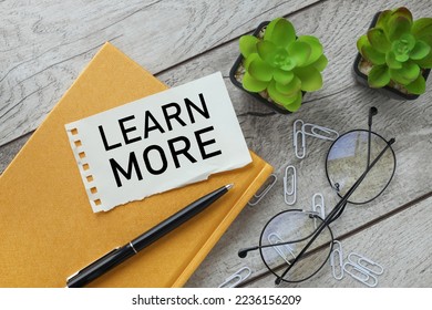 Learn More torn paper with text on a light wooden background. glasses potted plant - Shutterstock ID 2236156209