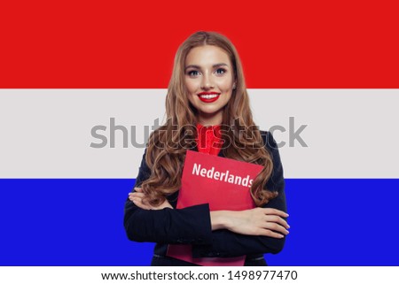 Learn netherlandish language. Happy woman student with book against the Netherlands flag background. Book with inscription neterlandish on netherlandish language