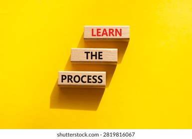 Learn the process symbol. Concept words learn the process on wooden blocks arranged as steps. Learning and development concept. Yellow background. Copy space.