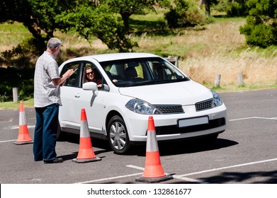 Learner driver girl with instructor taking lessons