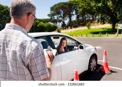 Learner driver girl with instructor taking lessons