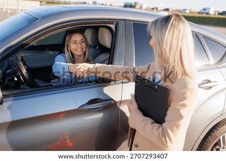 Learner Driver Shaking Hands with Instructor after Successful Driving Test