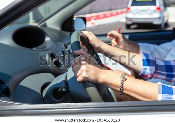 Learner driver student learning to drive a car\
with instructor