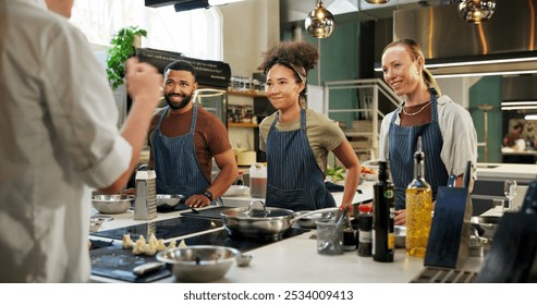 Learning, chef and group in kitchen, cooking and listening to instruction, mentor and teaching in hospitality. Professional, people and culinary students with smile and skills for fine dining - Powered by Shutterstock