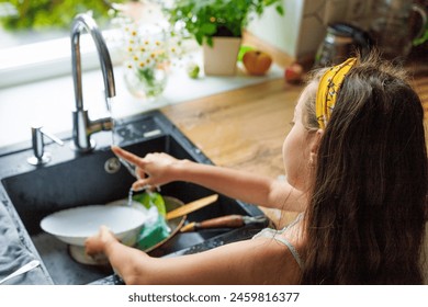 Learning, children and cleaning dishes in kitchen, girl or helping to wash, dry and clean house with water. Kids, washing and cloth to wipe plates, cutlery or teaching housework to girls - Powered by Shutterstock