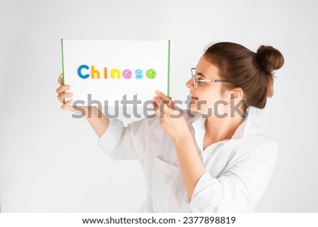Learning Chinese educational courses. Native tutor, woman teacher in glasses with magnetic sign in hands. Study foreign language in online school. Speaking,reading,writing,linguistic knowledge skills.