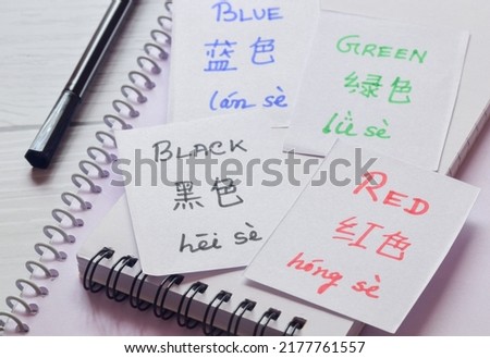 Learning Chinese Language with different colors name. Handwritten flash cards in English and Chinese languages and their translations. Selective focus on the text.