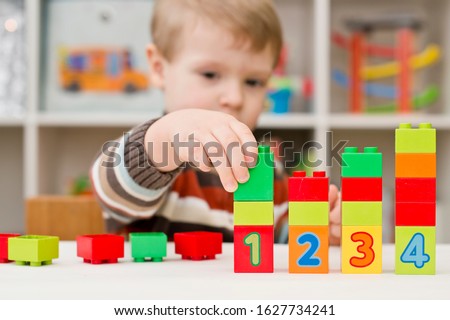 Learning to count. 2 year old boy stacking  Duplo blocks. children, infancy and education concept. formation and development of the child. Montessori and early development