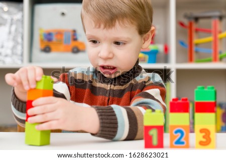 Learning to count. 2 year old boy stacking  Duplo blocks. children, infancy and education concept. formation and development of the child. Montessori and early development