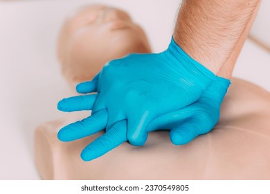 Learning CPR in a first aid course. Practicing cardiopulmonary resuscitation skills on a training dummy.