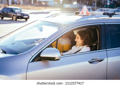 Learning To Drive, People Concept. Alert, Nervous Young Woman Student Driver Taking Driving Education Lesson Test From Male Instructor.